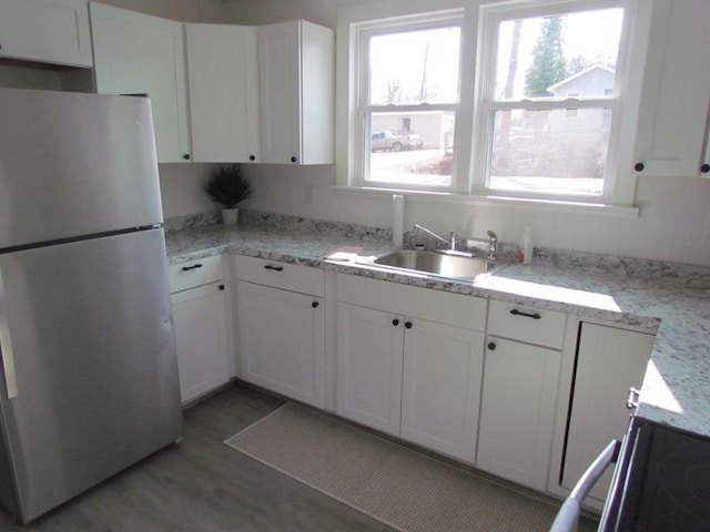 kitchen featuring white cabinets, sink, and stainless steel fridge