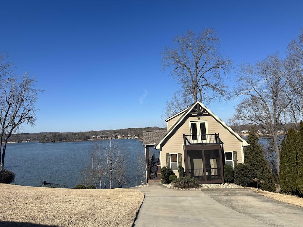 view of front of house with a balcony and a water view