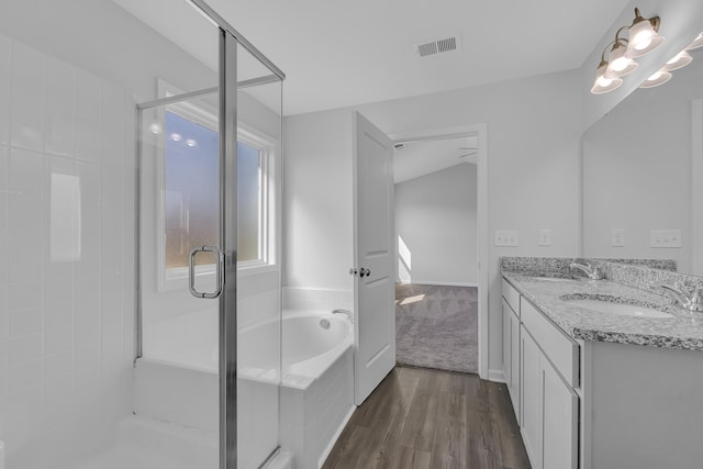 bathroom featuring hardwood / wood-style flooring, vanity, and separate shower and tub