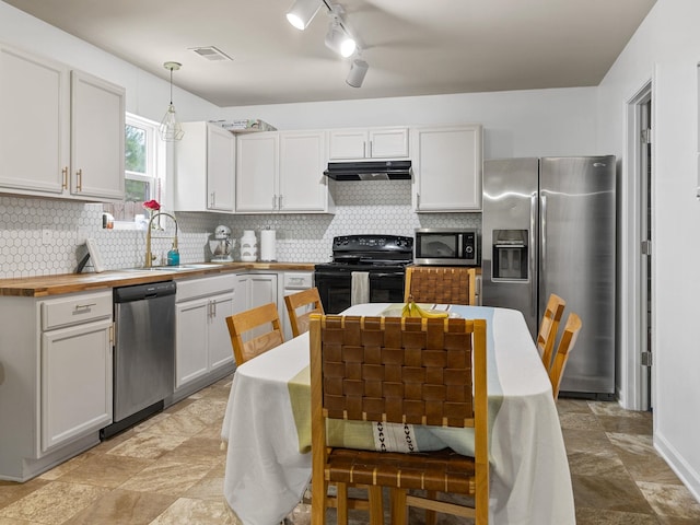 kitchen with sink, stainless steel appliances, decorative backsplash, white cabinets, and decorative light fixtures