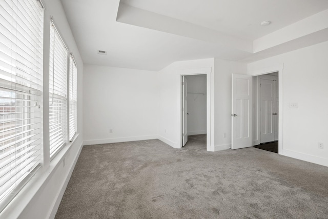 carpeted empty room featuring a raised ceiling