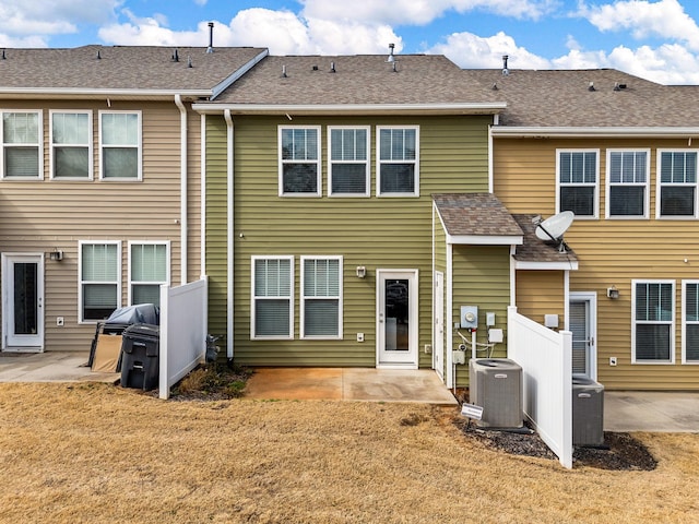 back of property with a lawn, a patio, and central air condition unit