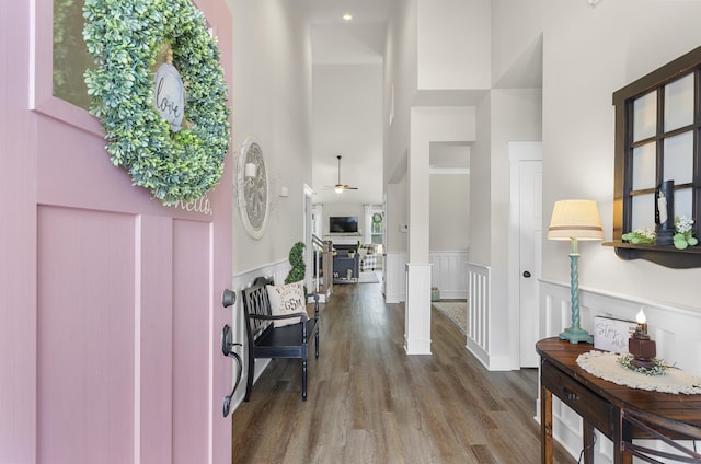 foyer entrance featuring hardwood / wood-style floors, a high ceiling, ceiling fan, and ornate columns