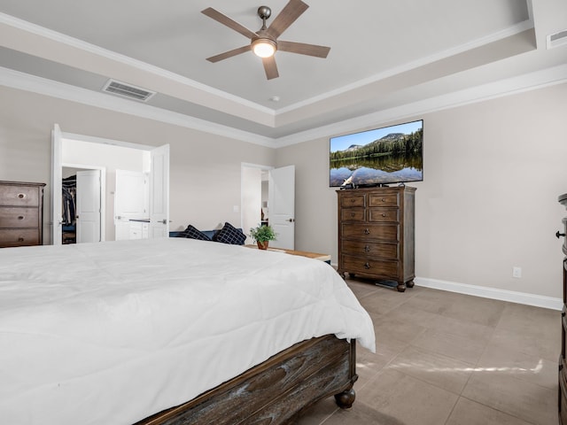 tiled bedroom with a spacious closet, ornamental molding, a tray ceiling, a closet, and ceiling fan