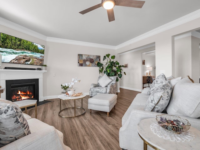 living room with hardwood / wood-style flooring, ornamental molding, and ceiling fan