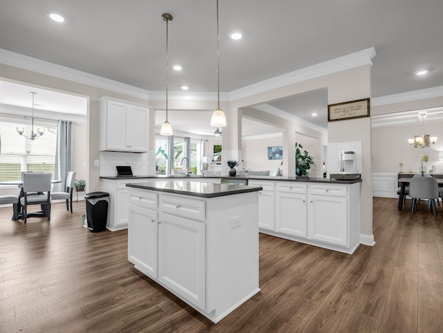 kitchen with an inviting chandelier, hanging light fixtures, and white cabinets