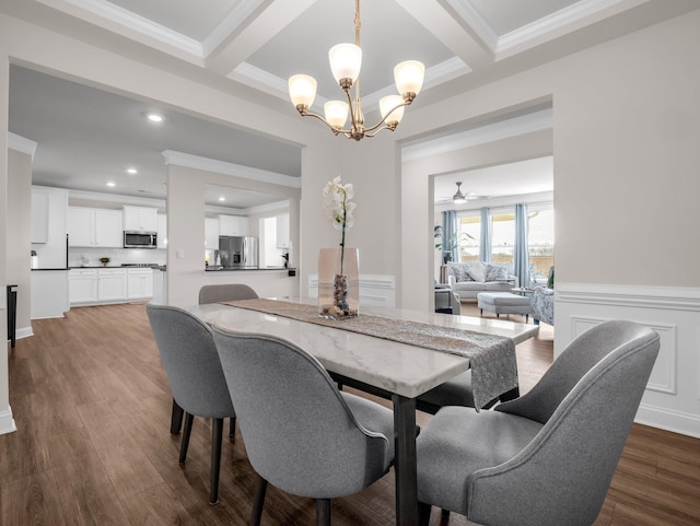 dining room featuring dark wood-type flooring, ornamental molding, beam ceiling, and ceiling fan with notable chandelier