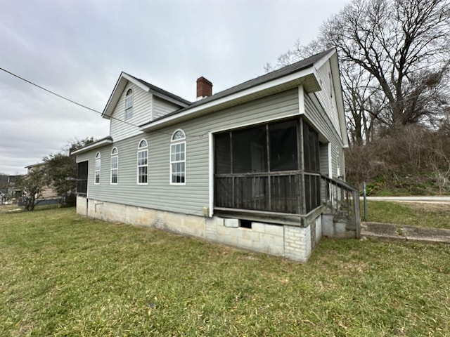 view of side of property featuring a lawn and a sunroom