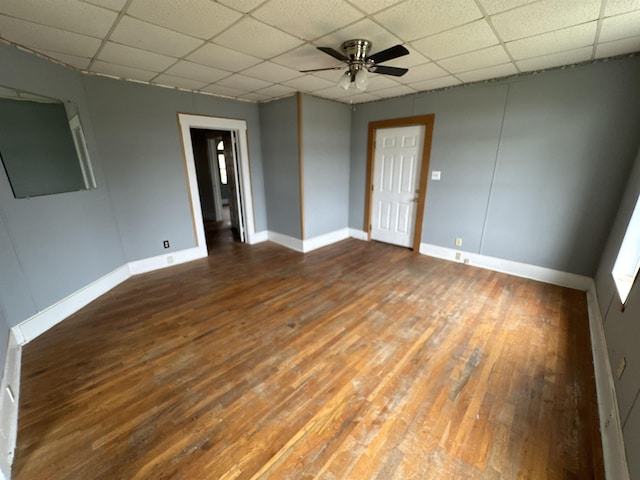 spare room with ceiling fan, dark hardwood / wood-style floors, and a drop ceiling