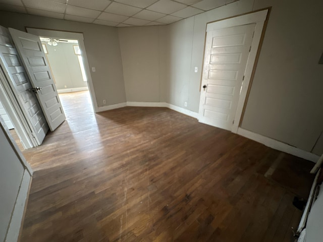 empty room featuring ceiling fan, a paneled ceiling, and hardwood / wood-style floors