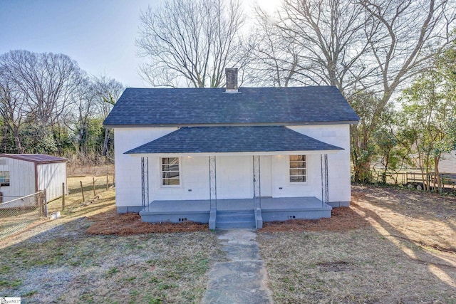 view of front of home with covered porch and a storage unit