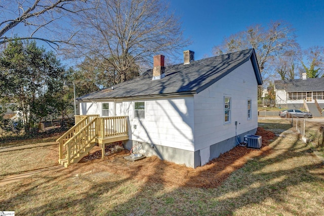 back of property with a lawn and central air condition unit