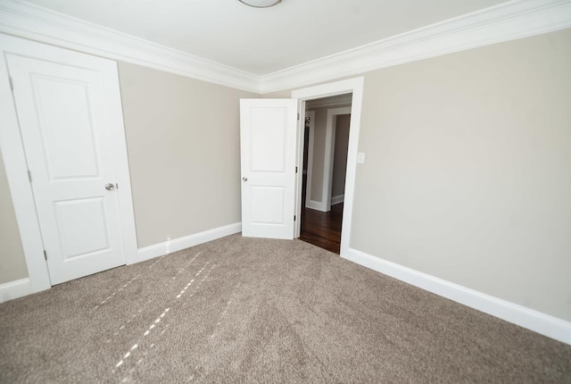 empty room featuring ornamental molding and carpet floors