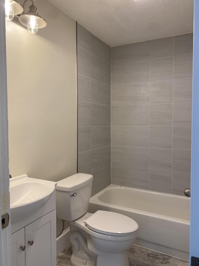 full bathroom with vanity, toilet, tiled shower / bath combo, and a textured ceiling