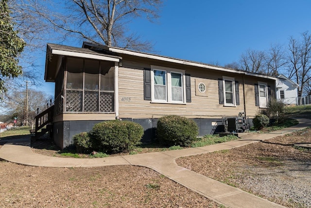 view of side of property with a sunroom and cooling unit
