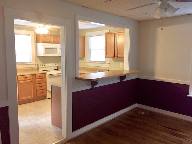 kitchen with light brown cabinetry, white appliances, a paneled ceiling, and ceiling fan