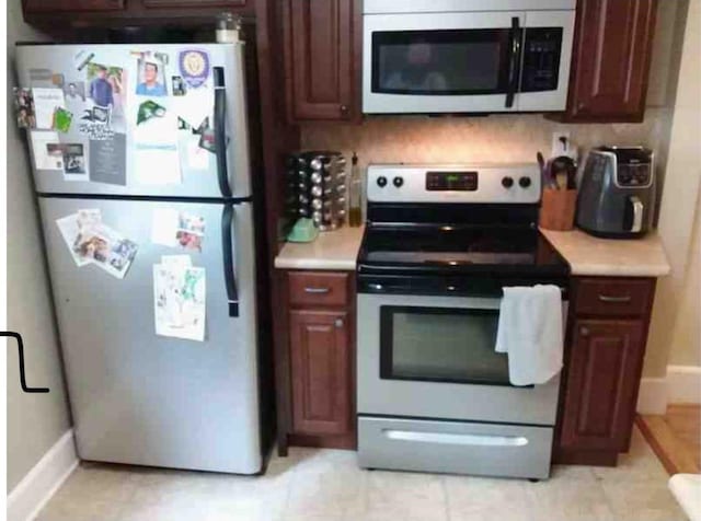 kitchen with refrigerator, stainless steel electric range, and backsplash