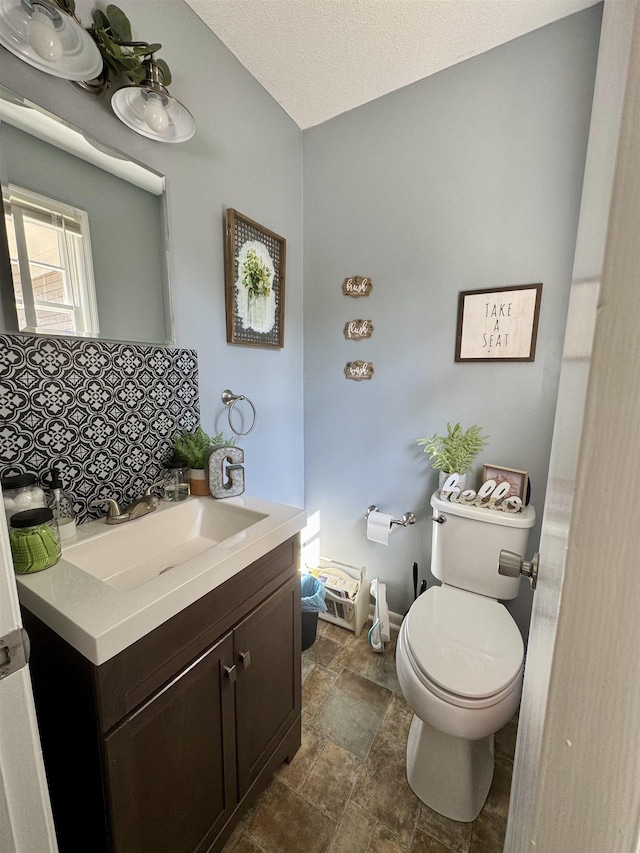 bathroom featuring vanity, toilet, and a textured ceiling