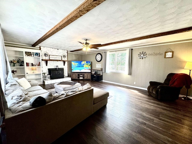 living room featuring ceiling fan, dark hardwood / wood-style floors, a textured ceiling, and beam ceiling