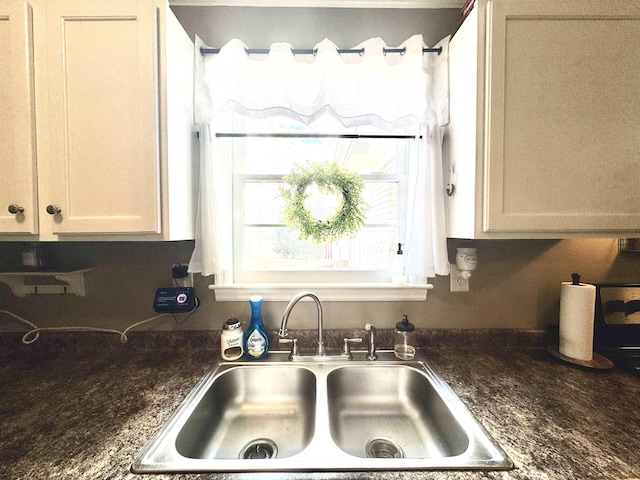 kitchen featuring white cabinetry, sink, and dark stone countertops