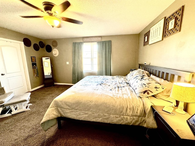 bedroom with ceiling fan, dark carpet, and a textured ceiling