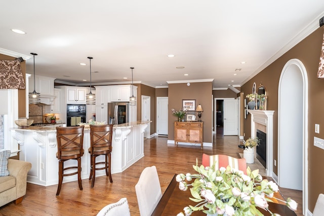 dining area with crown molding and light wood-type flooring