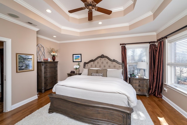 bedroom featuring hardwood / wood-style flooring, a raised ceiling, and ceiling fan