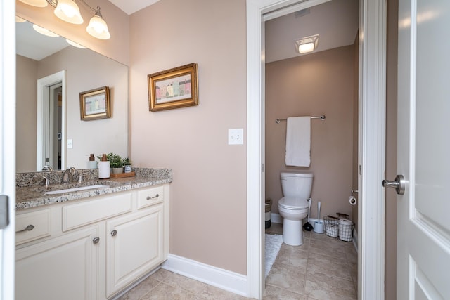 bathroom featuring vanity, tile patterned floors, and toilet