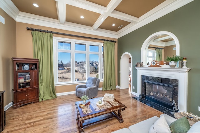 sitting room with beam ceiling, a premium fireplace, coffered ceiling, and light hardwood / wood-style floors