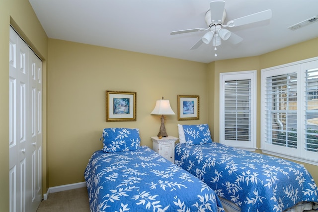 carpeted bedroom with multiple windows, a closet, and ceiling fan