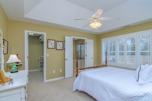 carpeted bedroom with ceiling fan, a walk in closet, and a closet