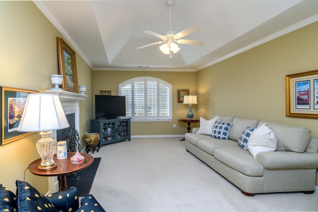 living room with a tray ceiling, carpet floors, ornamental molding, and ceiling fan