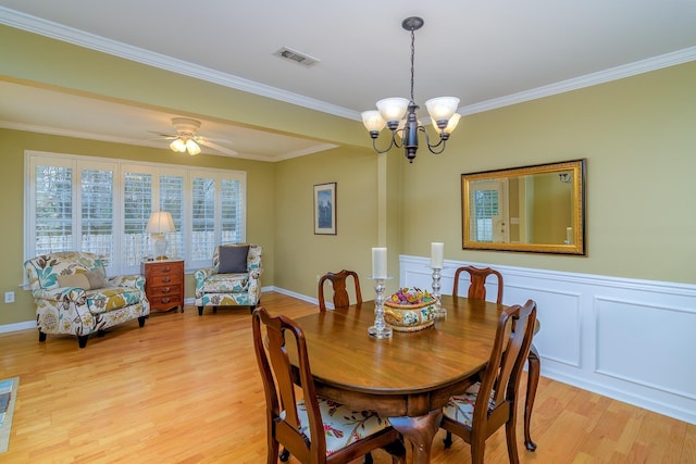 dining space featuring crown molding, ceiling fan with notable chandelier, and light hardwood / wood-style flooring