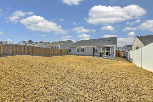 rear view of property featuring a lawn and a patio area