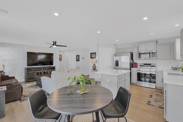 dining room featuring sink, light hardwood / wood-style floors, and ceiling fan