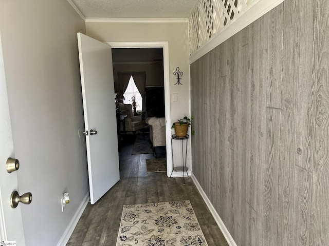 corridor featuring ornamental molding, a textured ceiling, and dark hardwood / wood-style flooring