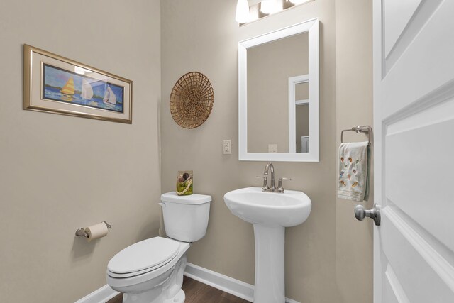 bathroom with toilet, sink, and hardwood / wood-style floors