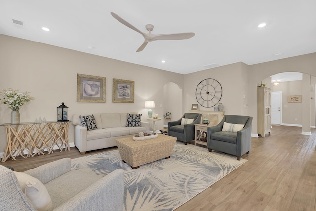 living room with light hardwood / wood-style flooring and ceiling fan