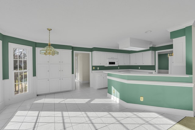 kitchen with crown molding, white cabinetry, an inviting chandelier, light tile patterned flooring, and decorative light fixtures