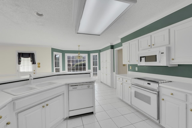 kitchen featuring white cabinetry, sink, white appliances, and hanging light fixtures