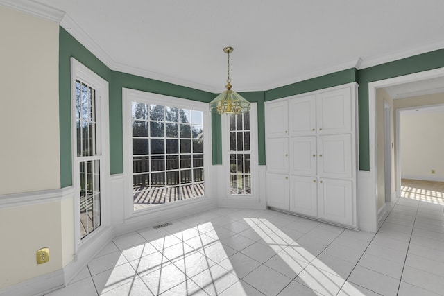 unfurnished dining area with ornamental molding, a chandelier, and light tile patterned flooring