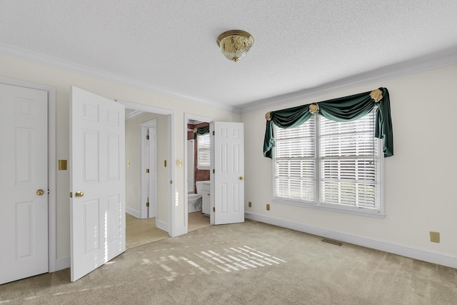 unfurnished bedroom with ornamental molding, light colored carpet, and a textured ceiling