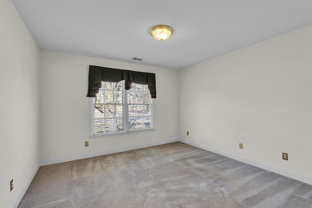 carpeted empty room with a textured ceiling