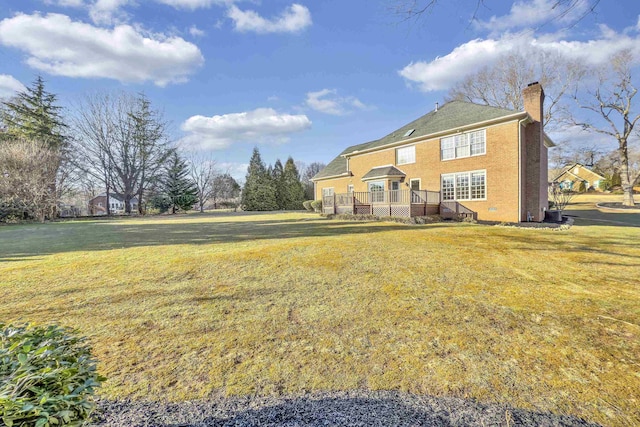 rear view of house with a yard and a deck