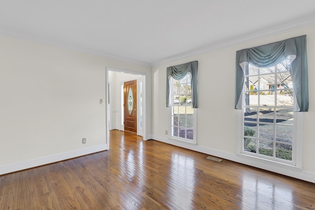 unfurnished room with ornamental molding and wood-type flooring