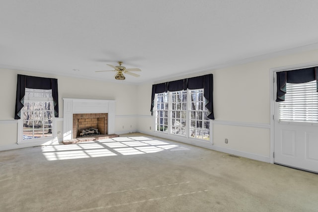 unfurnished living room featuring crown molding, light carpet, ceiling fan, and a fireplace