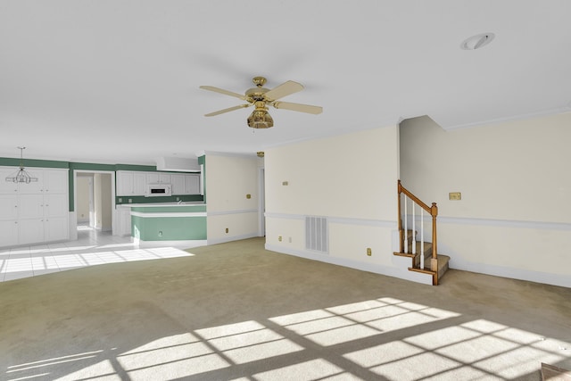 unfurnished living room with light carpet and ceiling fan