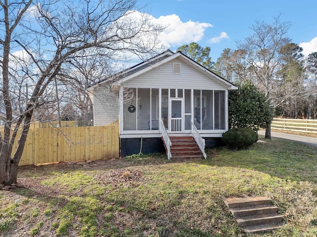 bungalow-style house featuring a sunroom and a front yard