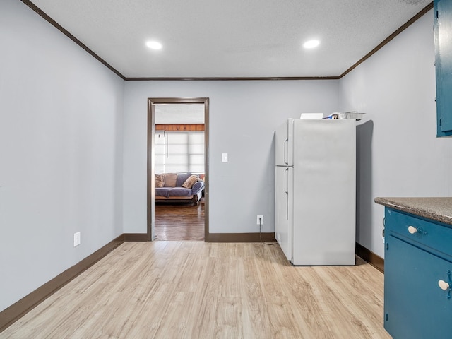 kitchen with ornamental molding, white fridge, and light hardwood / wood-style flooring