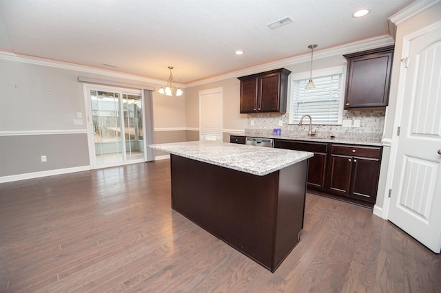 kitchen featuring sink, decorative light fixtures, a center island, dark brown cabinets, and dark hardwood / wood-style flooring